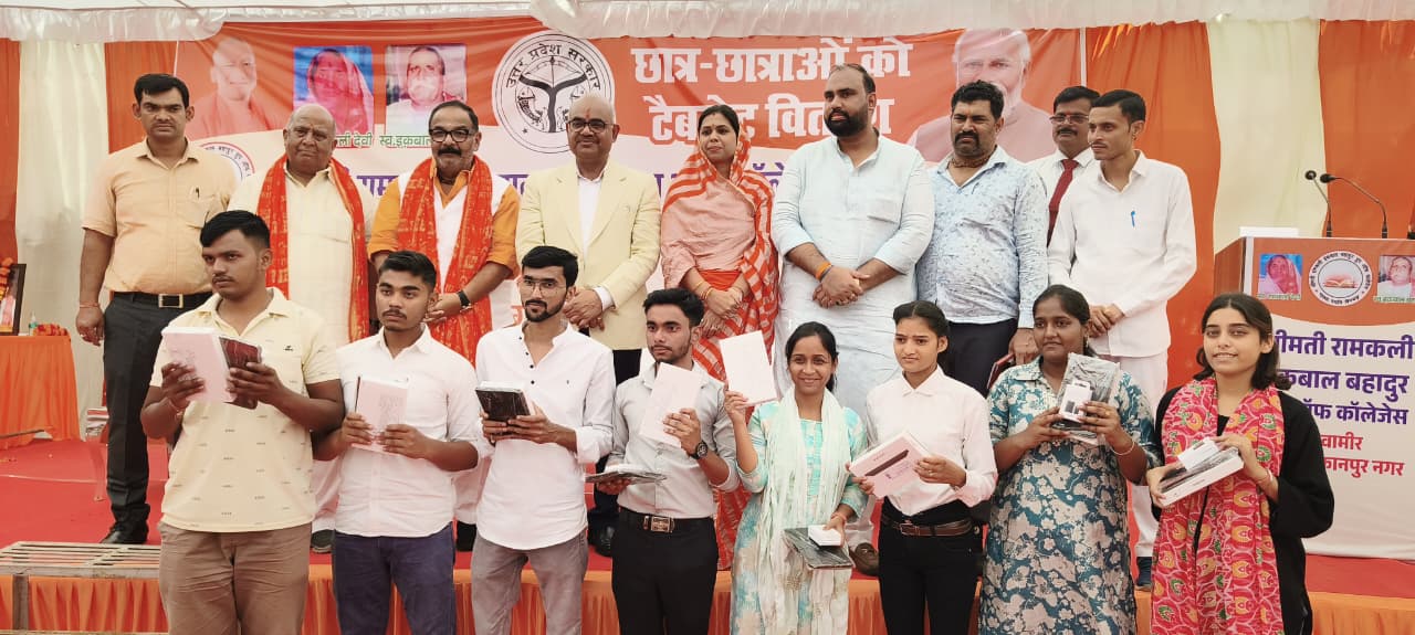 कार्यक्रम के दौरान छात्र को टेबलेट वितरित करते कार्यक्रम के दौरान छात्र को टेबलेट वितरित करते