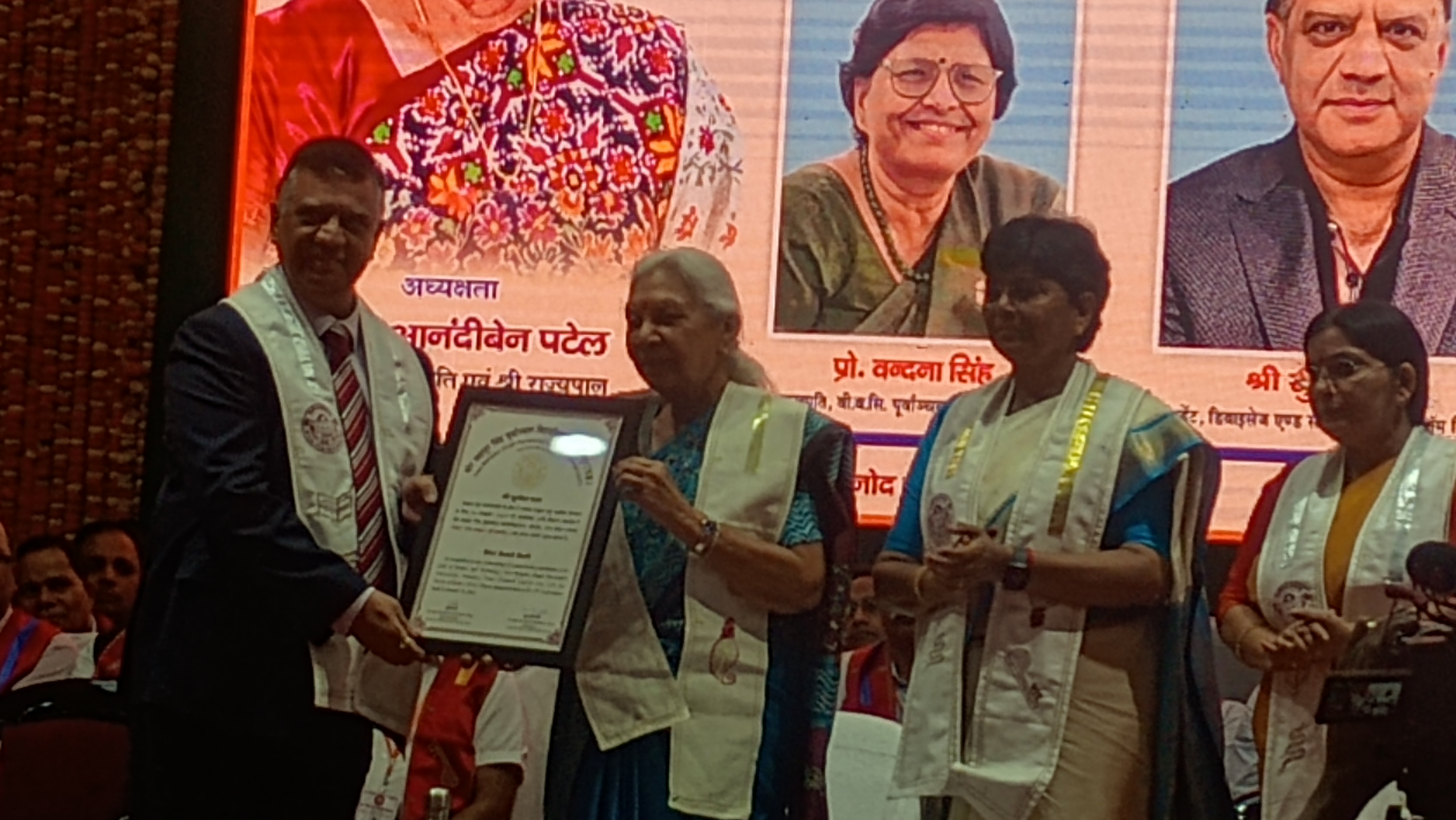 दीक्षांत समारोह में राज्यपाल श्रीमती आनंदी बेन पटेल मंच पर बच्चों को मेडल देते हुए दीक्षांत समारोह में राज्यपाल श्रीमती आनंदी बेन पटेल मंच पर बच्चों को मेडल देते हुए