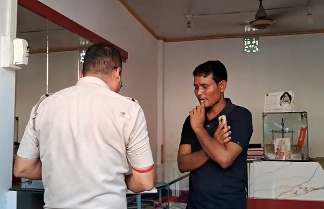 पुलिस के साथ बात करते हुए दुकानदार
