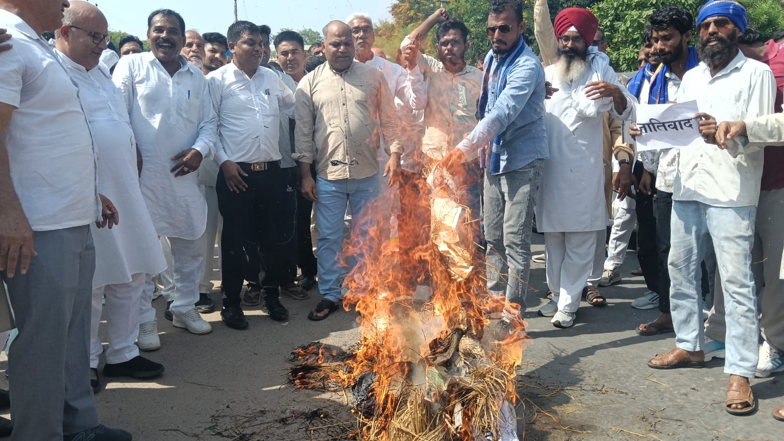 मांगों को लेकर पुतला फूंकते हुए कार्यकर्ता।