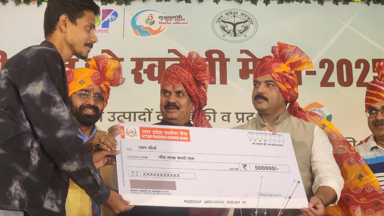 सीएम युवा उद्यमी विकास योजनान्तर्गत लाभार्थियों को चेक प्रदान करते हुए जिलाधिकारी और एमएलसी बृजेश सिंह