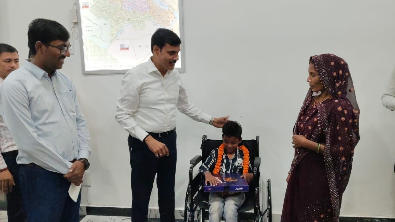 नीलेश को व्हीलचेयर देते डीएम बलिया नीलेश को व्हीलचेयर देते डीएम बलिया