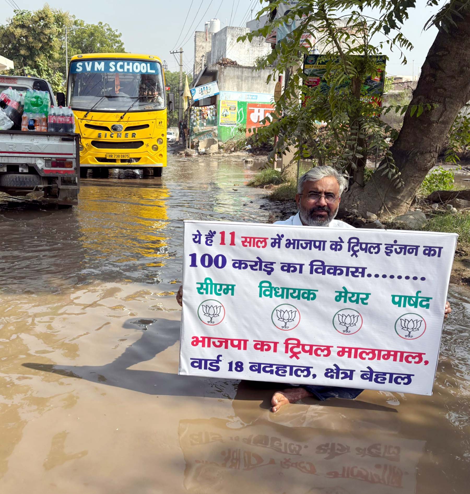 गुरुग्राम के गांव बादशाहपुर के वार्ड-18 में सीवरेज ओवरफ्लो से सडक़ पर भरे गंदे पानी में बैठकर विरोध जाहिर करते कांग्रेस नेता राजेश यादव।