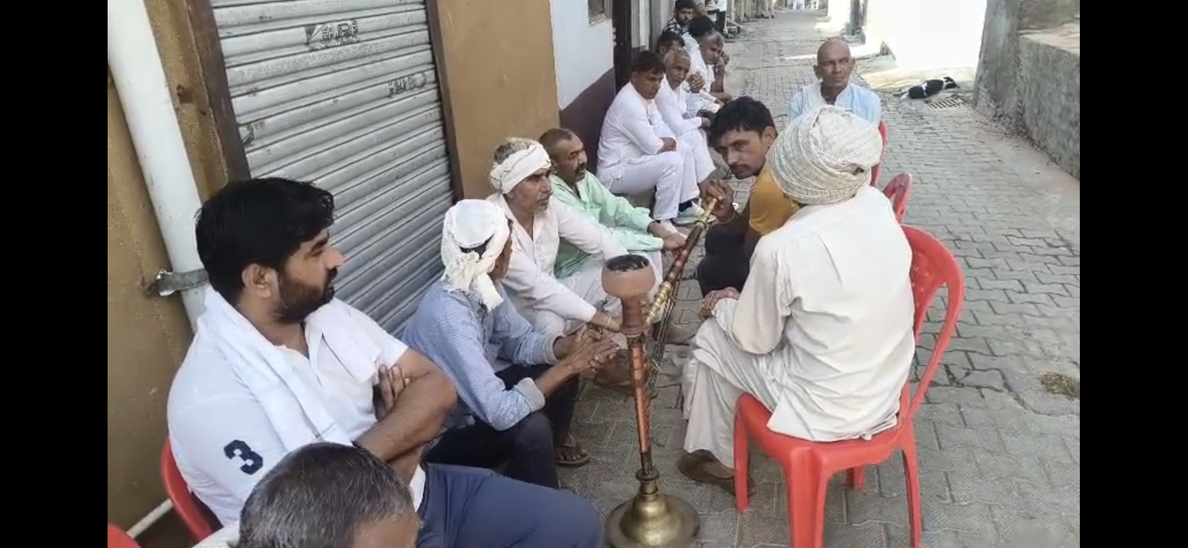 घर के सामने बैठे परिवार के लोग घर के सामने बैठे परिवार के लोग