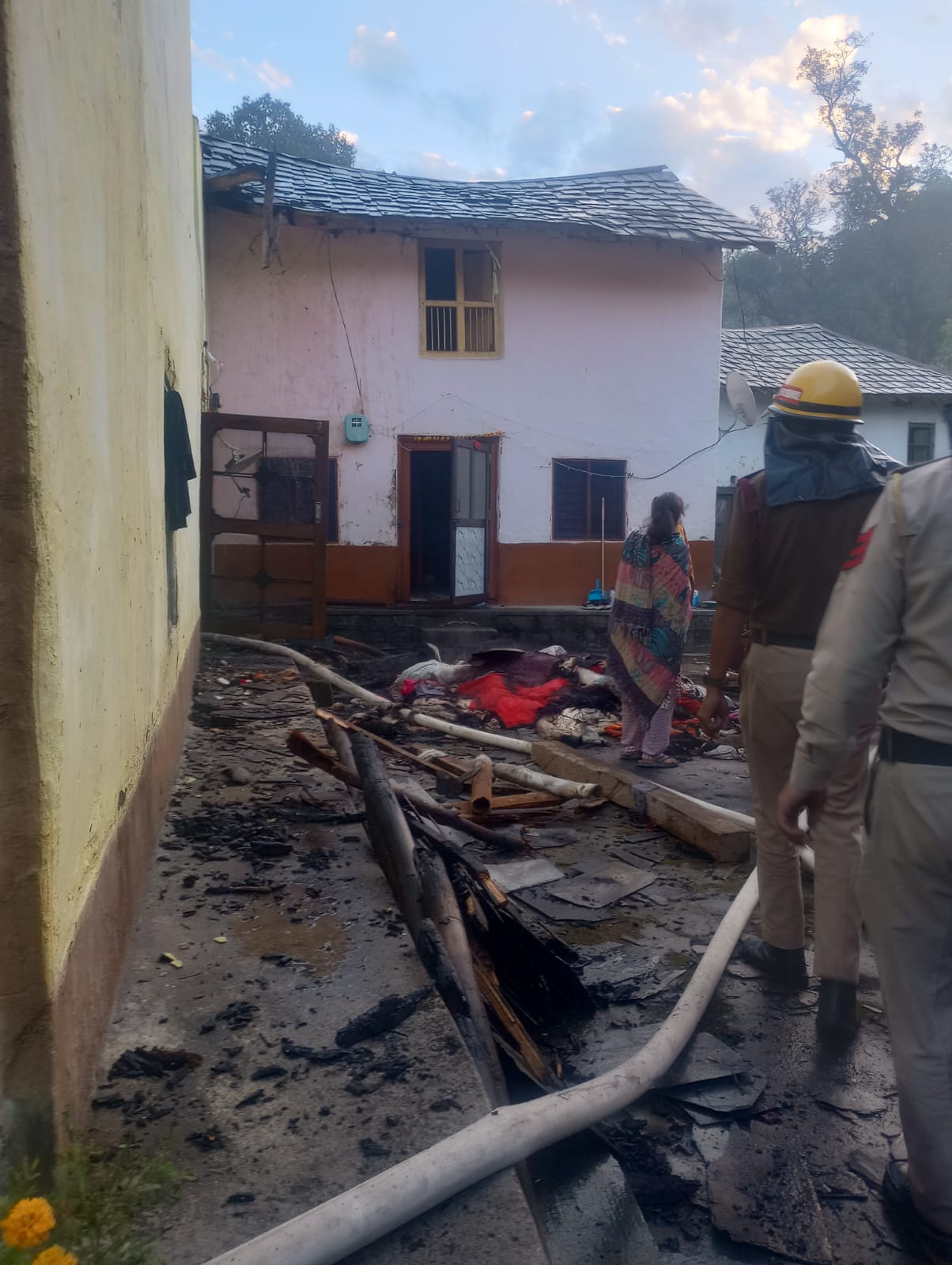 आग से क्षतिग्रस्त मकान में अग्निशमन विभाग के कर्मी।