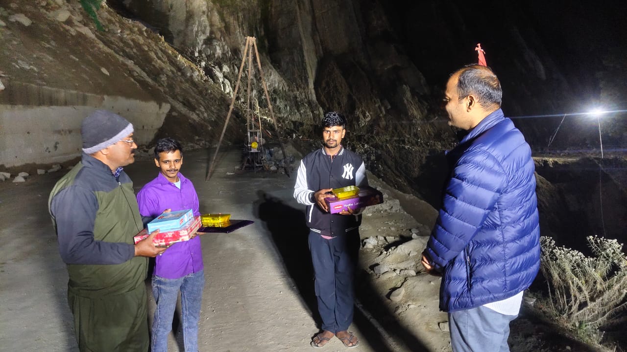 मजदूरों को मिठाई बांटते जिला अधिकारी मजदूरों को मिठाई बांटते जिला अधिकारी