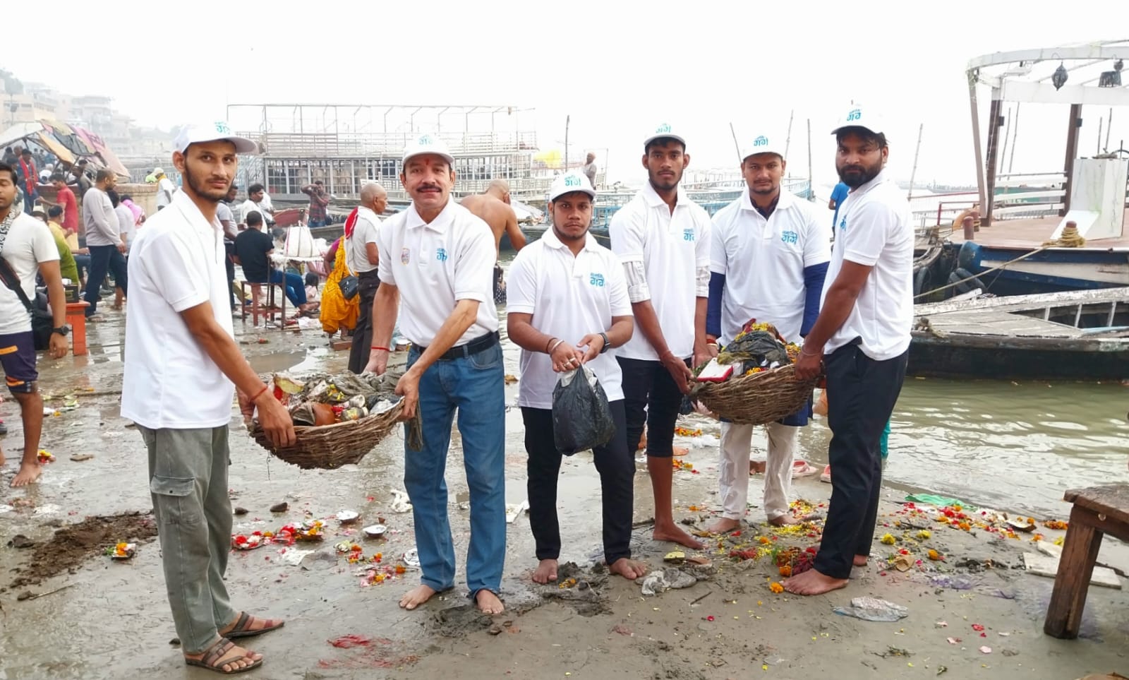 गंगा तट पर सफाई करते नमामि गंगे के सदस्य और निगम कर्मी