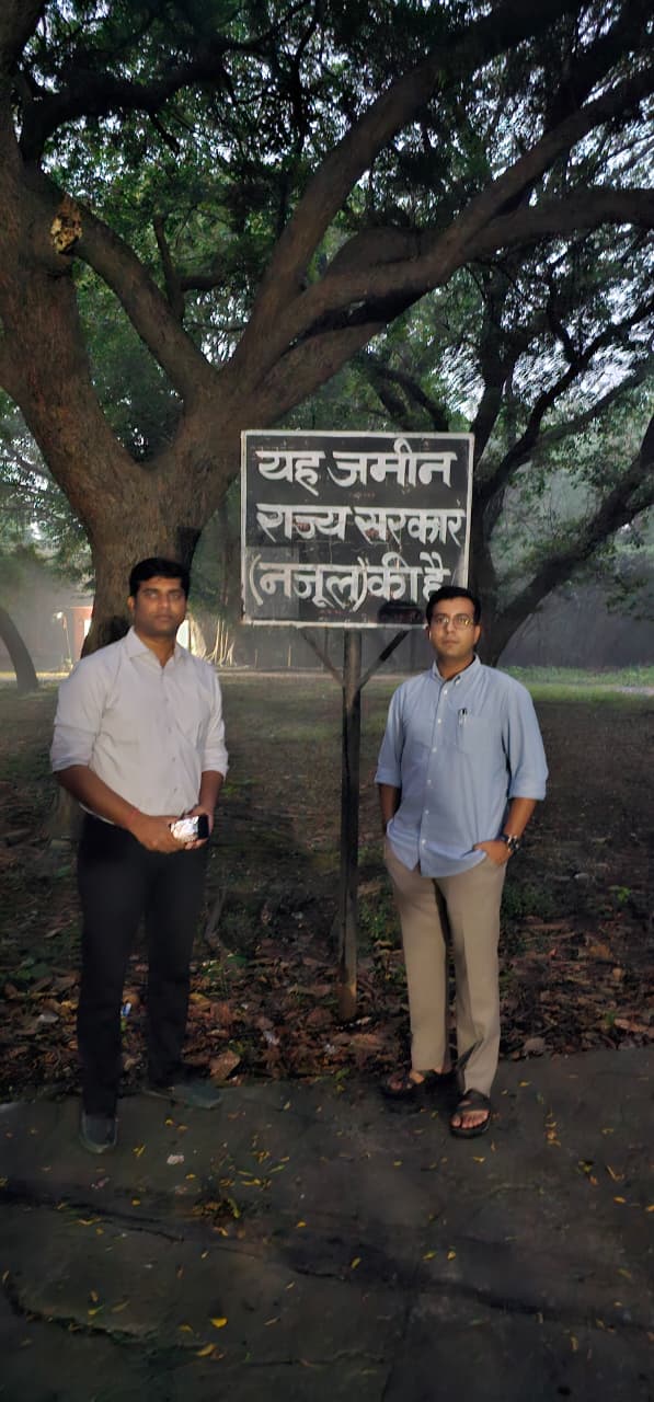 म्योर मिल की जमीन पर लगे सरकरी बोर्ड के पास खड़े प्रशासनिक अधिकारी म्योर मिल की जमीन पर लगे सरकरी बोर्ड के पास खड़े प्रशासनिक अधिकारी