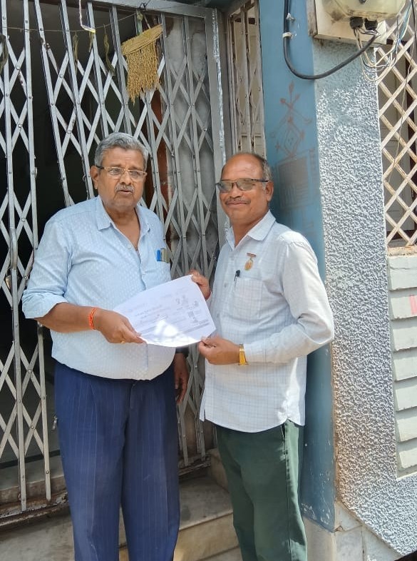 घर पहुंचकर जानकारी देते हुए कर्मचारी।