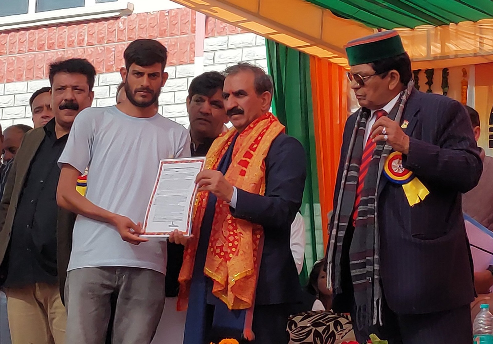 मुख्यमंत्री से जमीन के कागज लेते हुए। मुख्यमंत्री से जमीन के कागज लेते हुए।