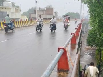 बारिश के बाद भी पुल में गुजरते लोग बारिश के बाद भी पुल में गुजरते लोग