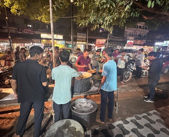 मंदिर प्रांगण में भंडारा प्रसाद बांटते हुए लोग मंदिर प्रांगण में भंडारा प्रसाद बांटते हुए लोग