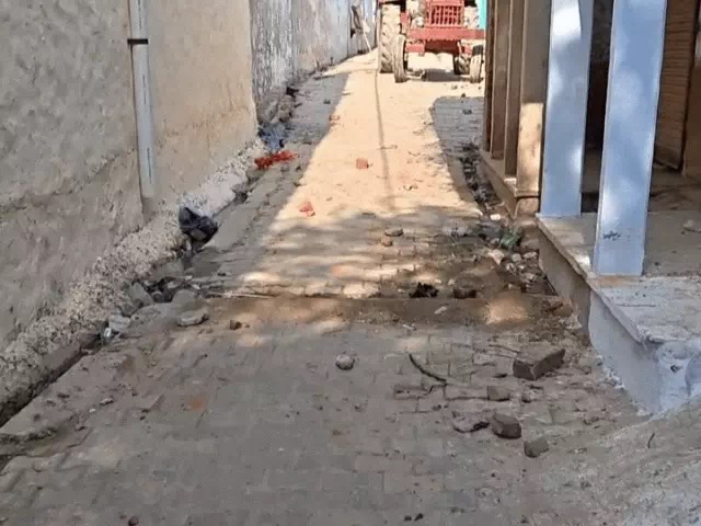 पथराव के बाद गली में पड़े पत्थर।