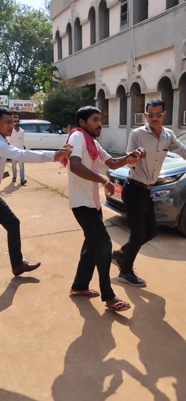 युवक को ले जाते हुए कर्मचारी।