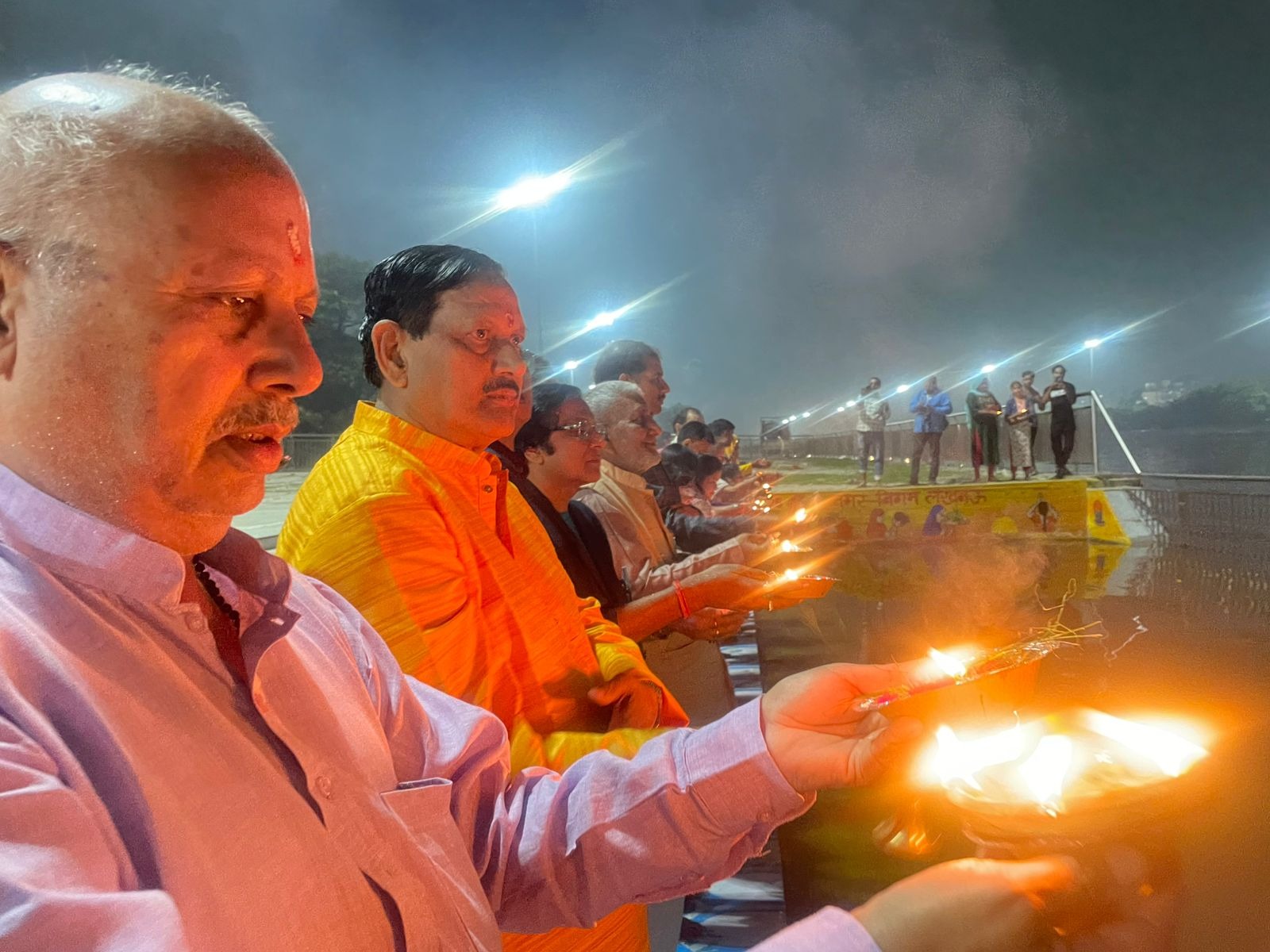 गोमती नदी के तट पर देव दीपावाली पर दीप जलाकर आरती करते लोग गोमती नदी के तट पर देव दीपावाली पर दीप जलाकर आरती करते लोग