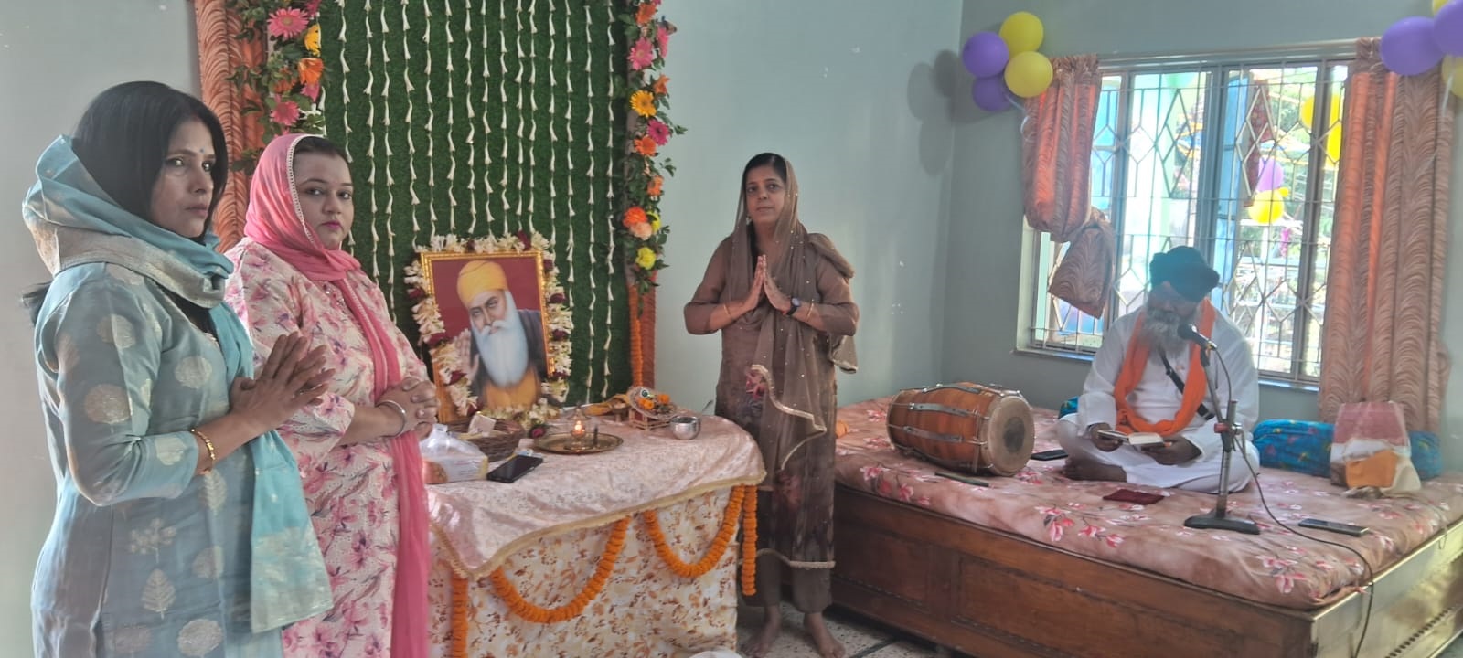 गुरुनानक देव की जंयती पर उनके चित्र पर माथा टेकते श्रद्धालु व लंगर में शामिल लोग