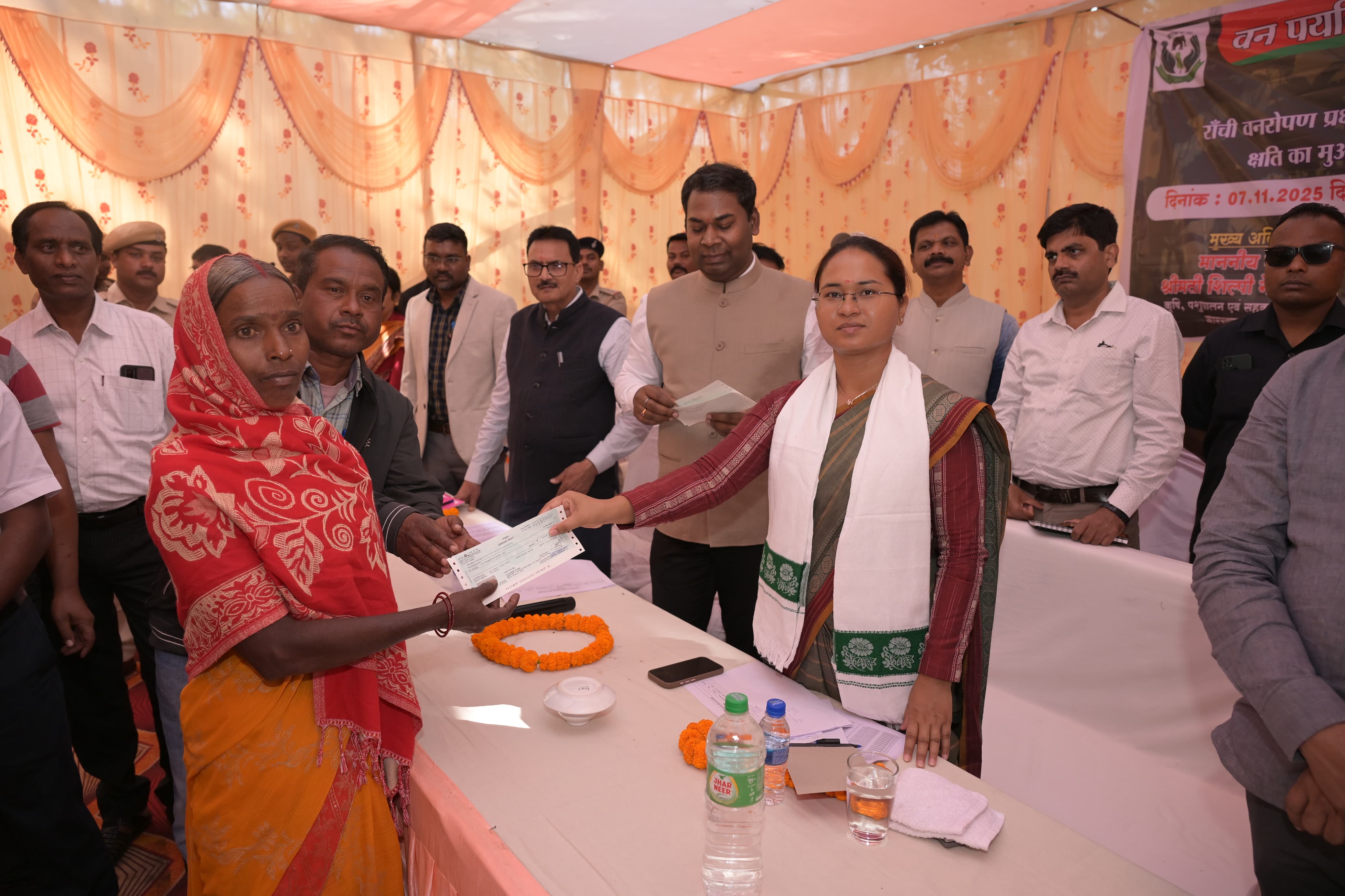 ग्रामीणों को मुआवजा की डिमांड ड्राफ्ट सौंपते मंत्री समेत अन्य ग्रामीणों को मुआवजा की डिमांड ड्राफ्ट सौंपते मंत्री समेत अन्य
