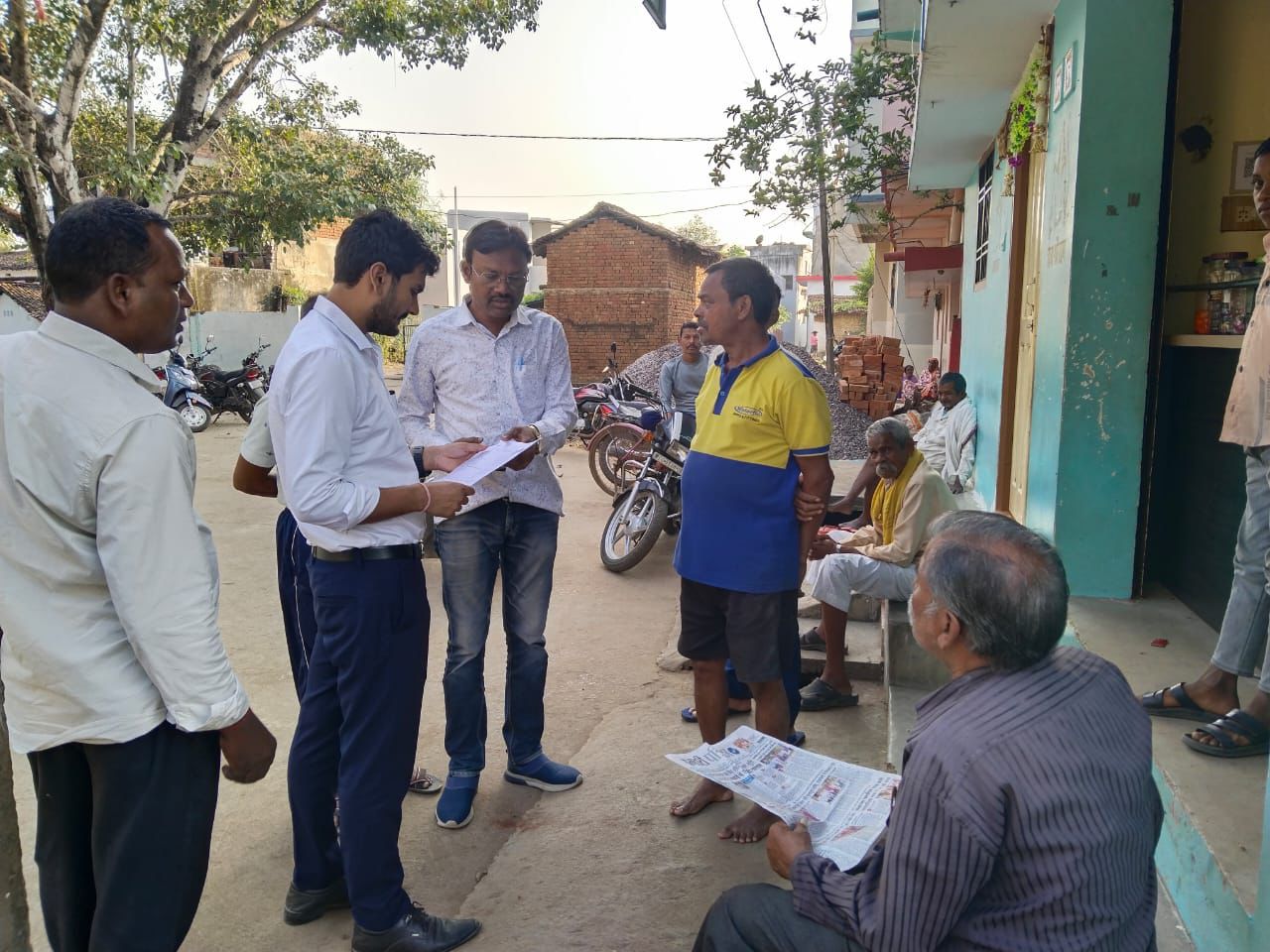 मतदाताओं को गणना प्रपत्र बांट रहे बूथ लेवल अधिकारी।