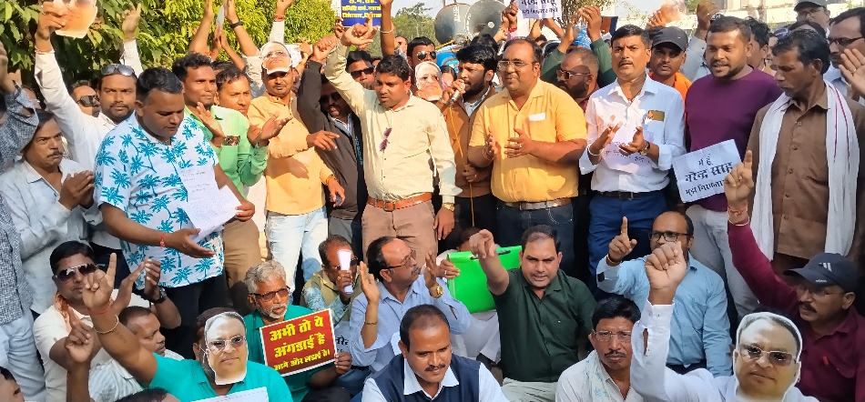 बैरिकेड के सामने जमीन में बैठकर विरोध प्रदर्शन करते हुए सहकारी समिति के कर्मचारी।