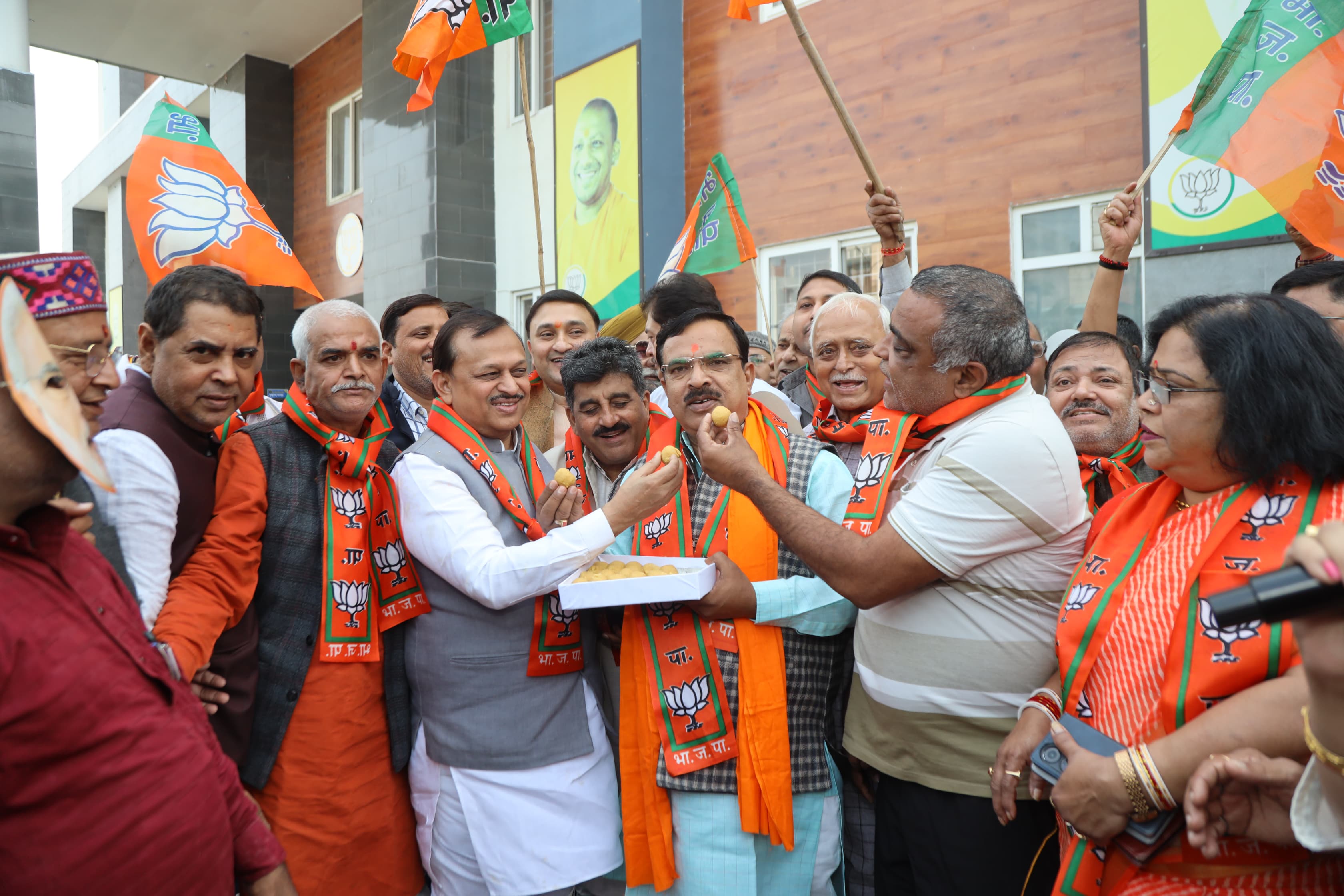 एक दूसरे को मिठाई खिलाकर जीत की खुशी का इजहार करते भाजपा कार्यकर्ताओं का छायाचित्र एक दूसरे को मिठाई खिलाकर जीत की खुशी का इजहार करते भाजपा कार्यकर्ताओं का छायाचित्र