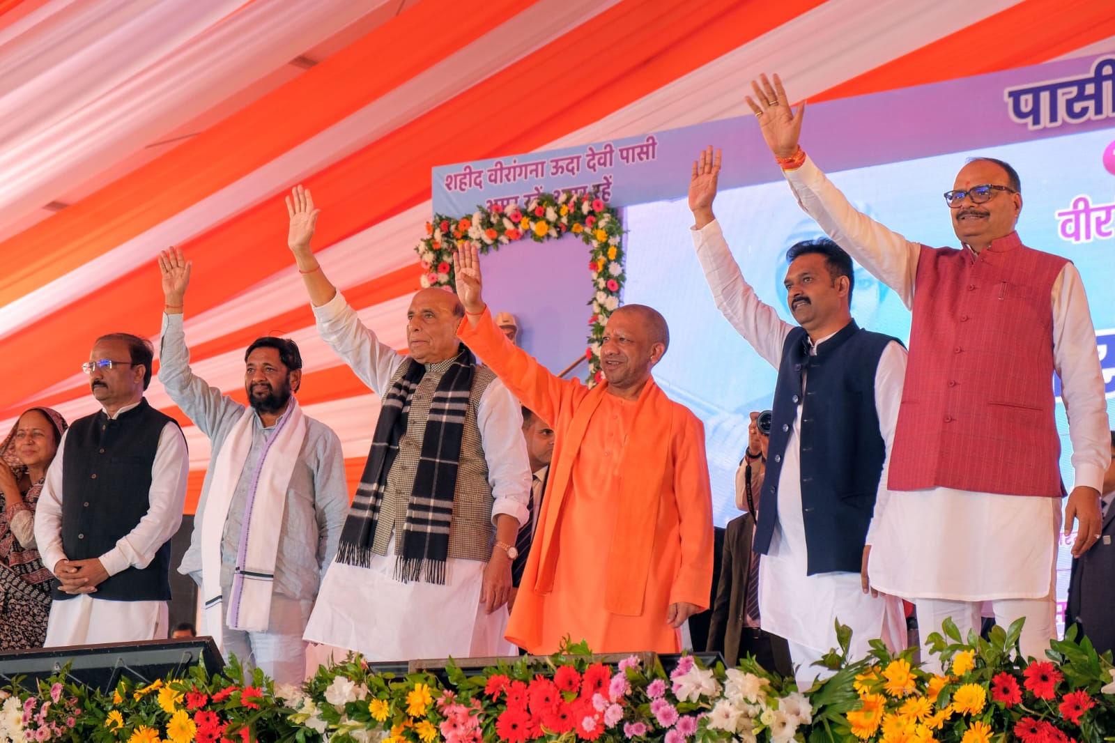 मंच से रक्षा मंत्री राजनाथ सिंह के साथ मुख्यमंत्री योगी आदित्यनाथ वीरांगना ऊदा देवी पासी की प्रतिमा का अनावरण कार्यक्रम में ​जनता का अभिवादन करते हुए।