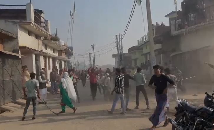 मोहनपुर में विवाद के दौरान एक-दूसरे पर पथराव करते दो पक्षों के लोग, मौके पर अफरा-तफरी का माहौल।