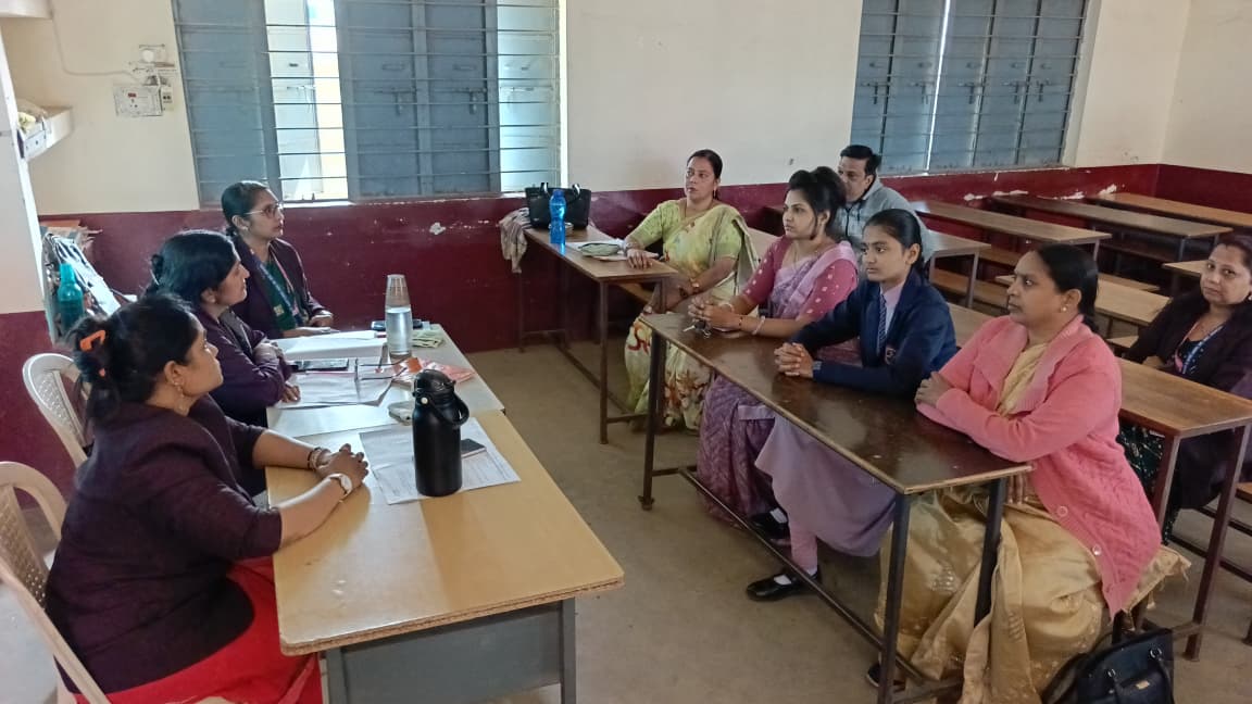 चर्चा करते हुए शिक्षक और पालक।