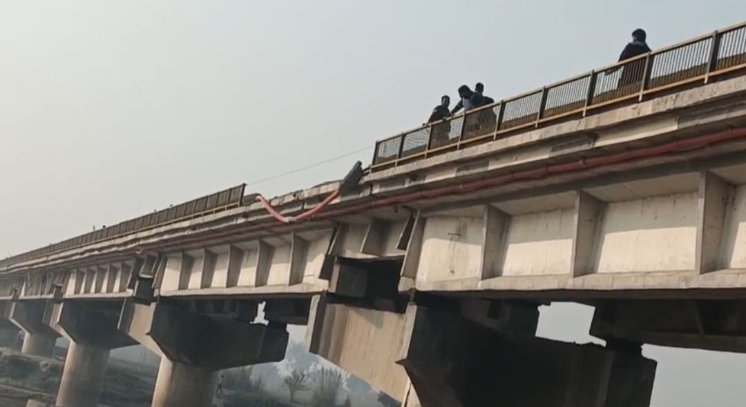 फर्रुखाबाद में रेलिंग तोड़ गन्ने से लदा ट्रक गंगा नदी में गिरने का फोटो।