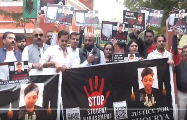 सेंट कोलंबस स्कूल के बाहर प्रदर्शन करते हुए छात्र के परिवार और दोस्त।