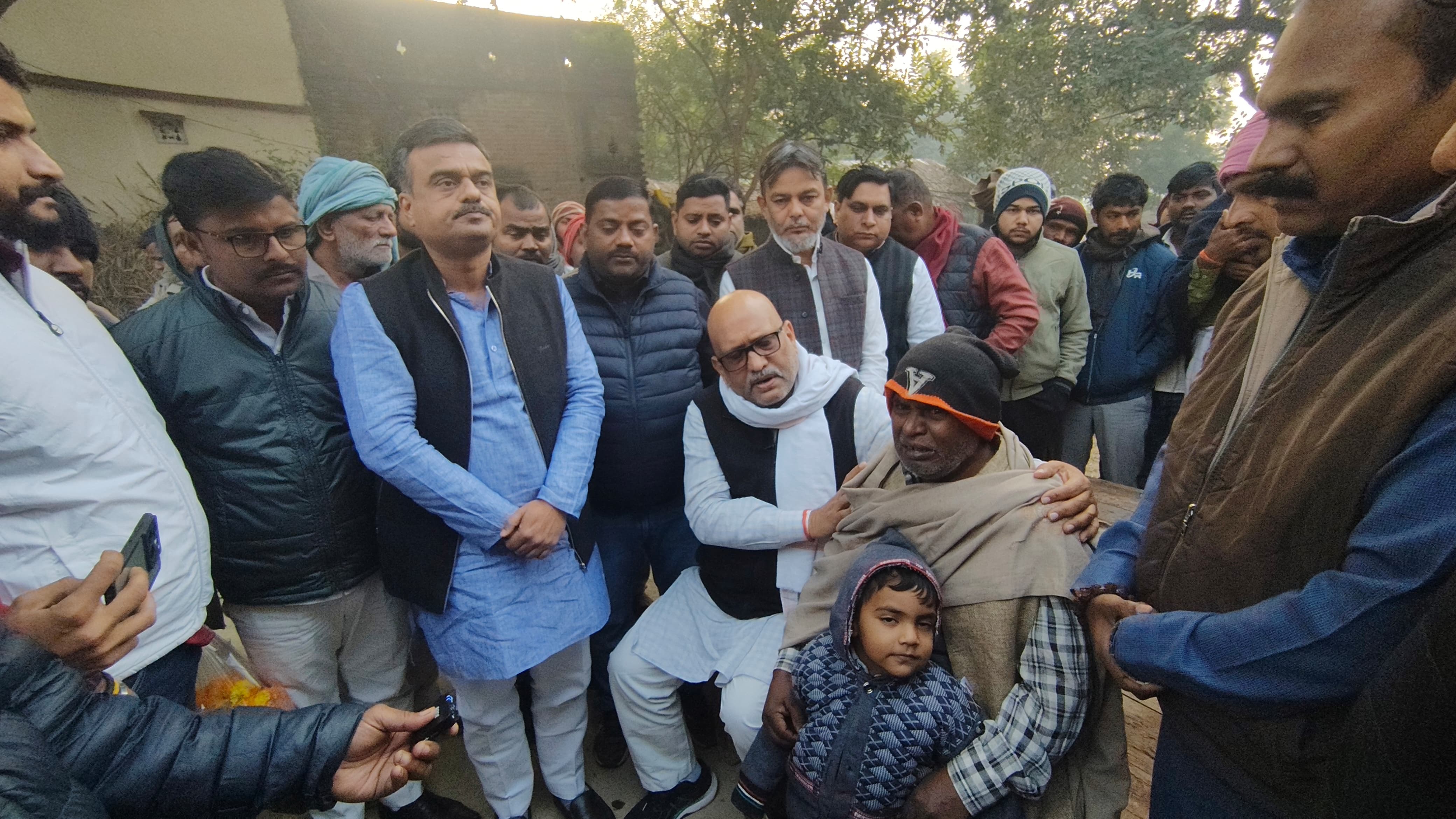 मृतक के बच्चे और पिता को सांत्वना देते हुए अजय राय