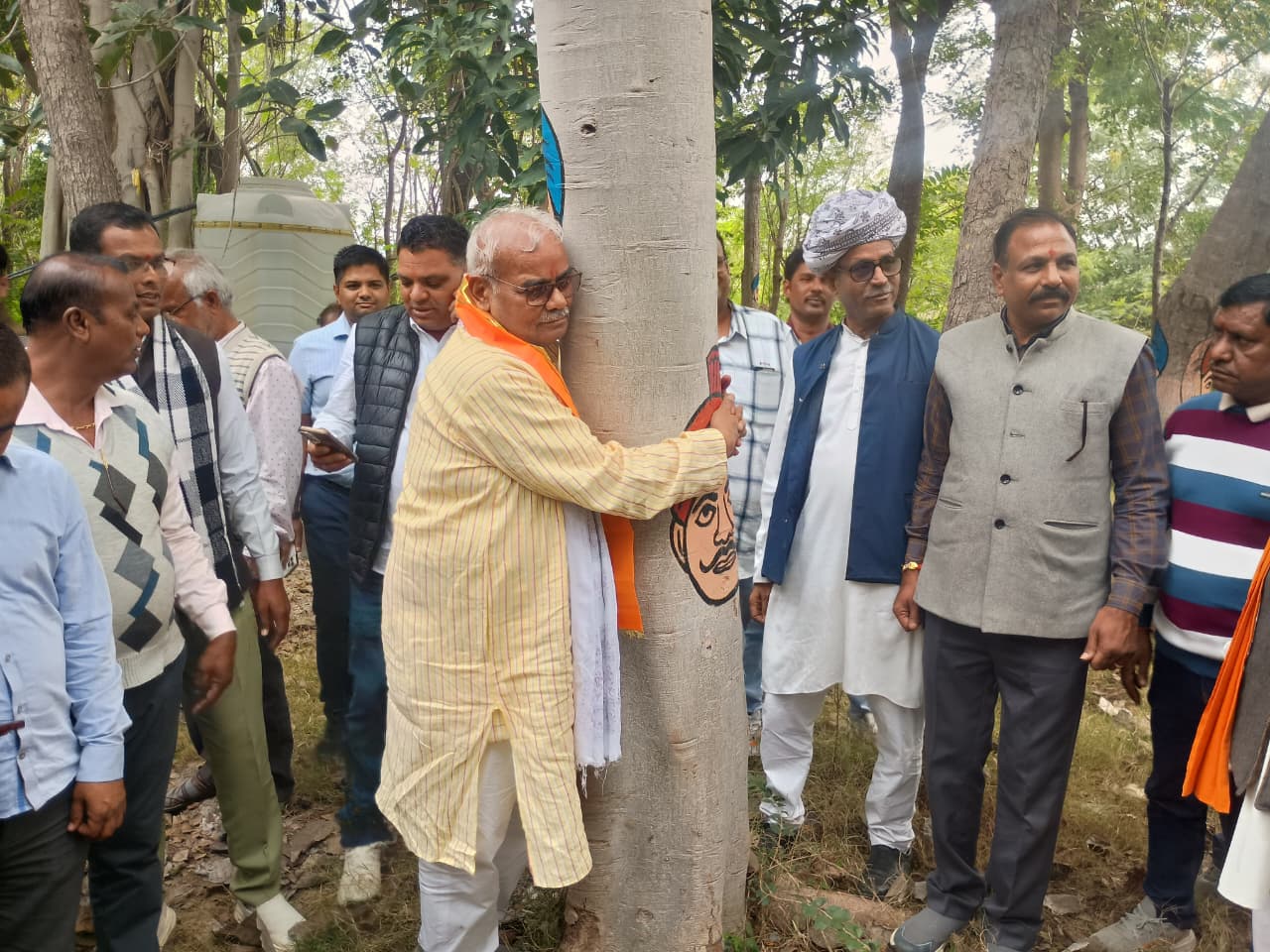 पेड़ को गले लगाते हुए शिक्षा मंत्री