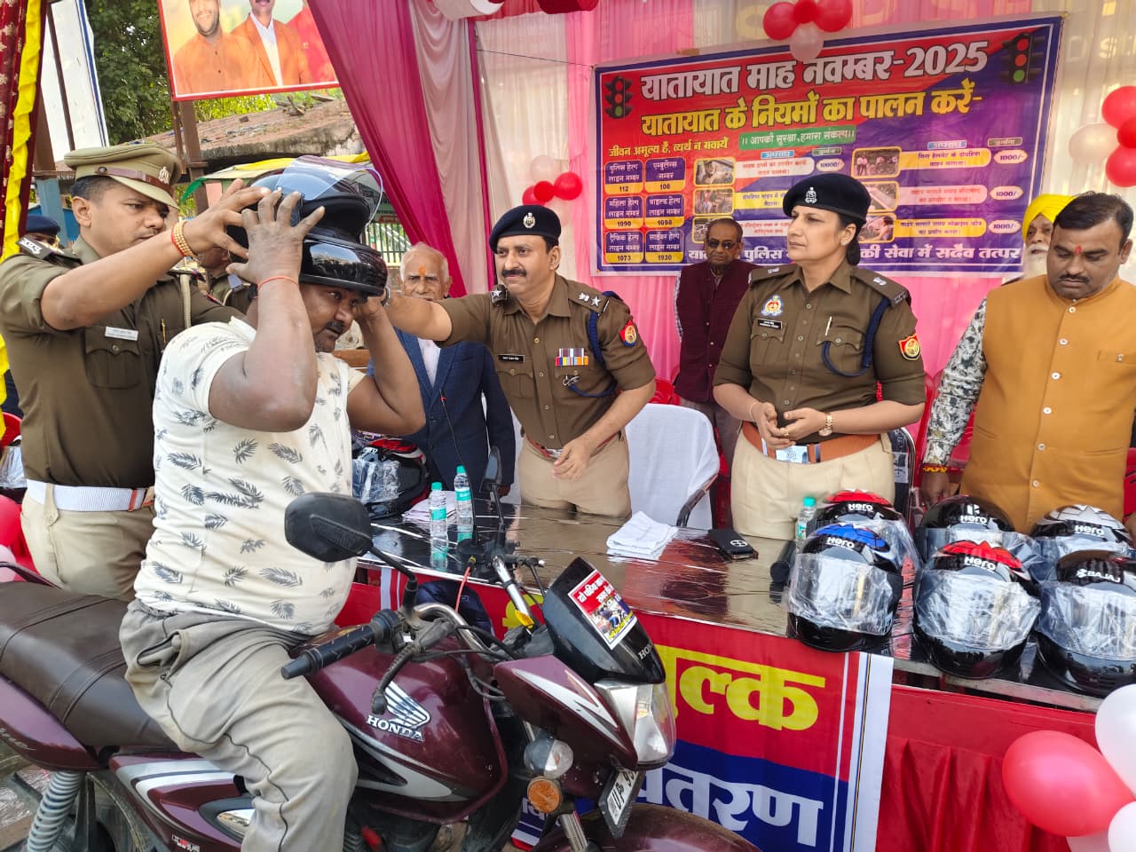 बाइक सवार को हेलमेट पहनाते अधिकारी