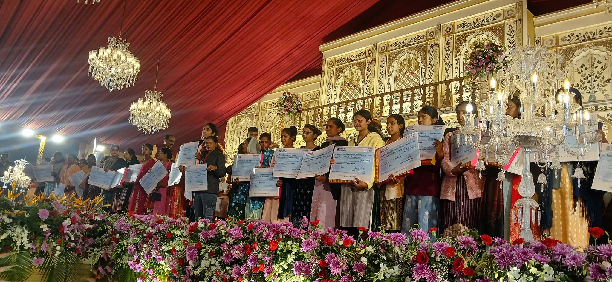 सभी कन्याएं हाथों में चेक लिए हुए