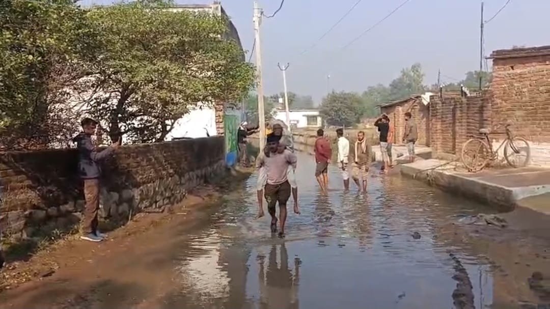 बुजुर्ग को कंधे में लादकर निकलता ग्रामीण