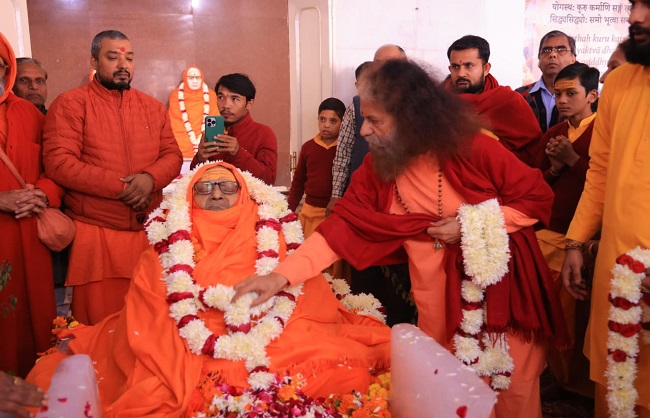 ब्रह्मलीन महामंडलेश्वर स्वामी असंगानंद सरस्वती को पुष्प अर्पित करते.