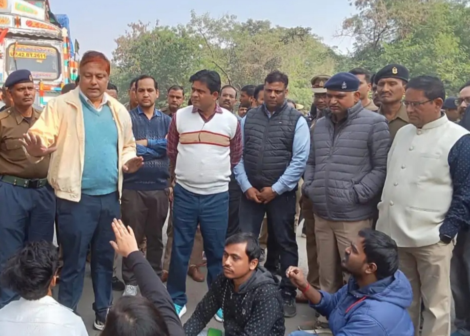 सड़क पर बैठ प्रदर्शन करते छात्र।