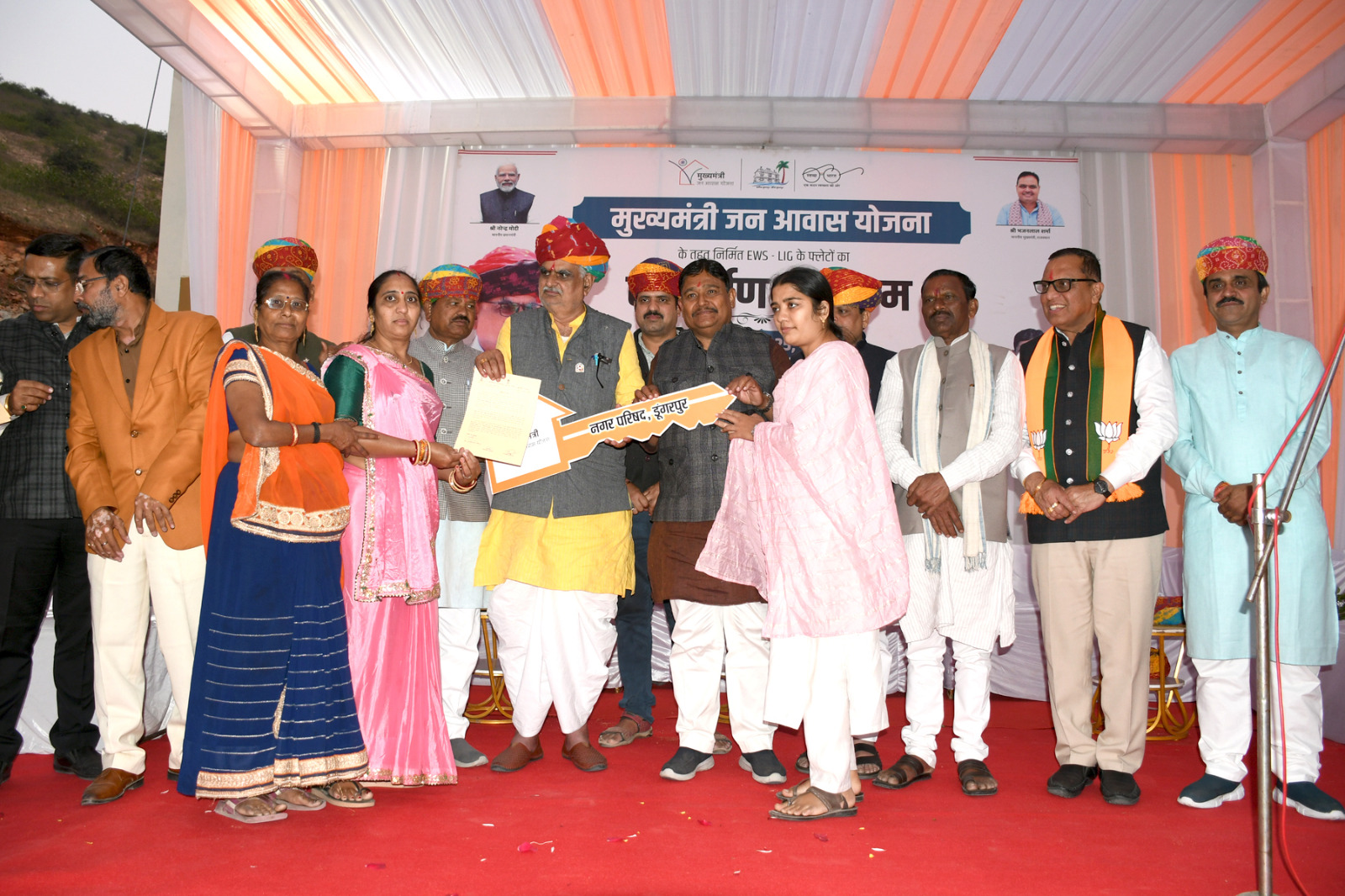 लाभार्थियों को आवास की प्रतीकात्मक चाबी सौपते हुए