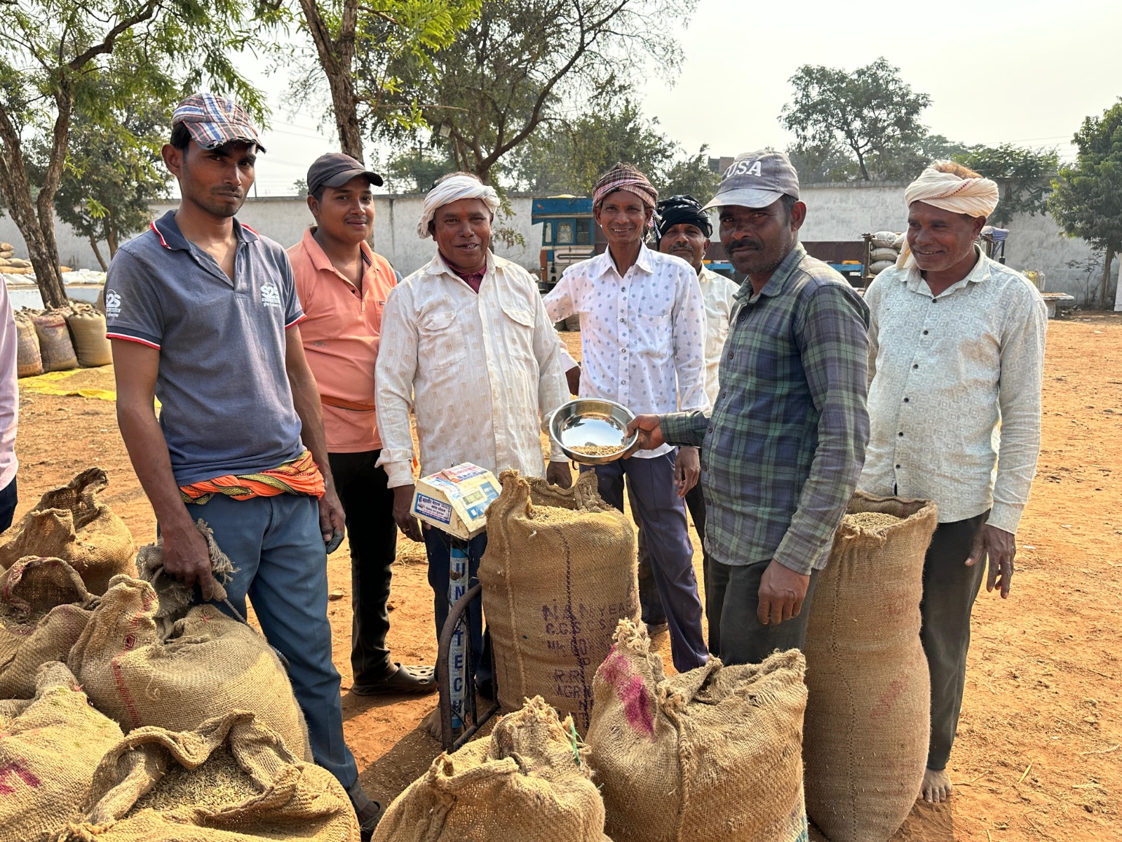 धान खरीदी केंद्र में धान तौलते हुए किसान।