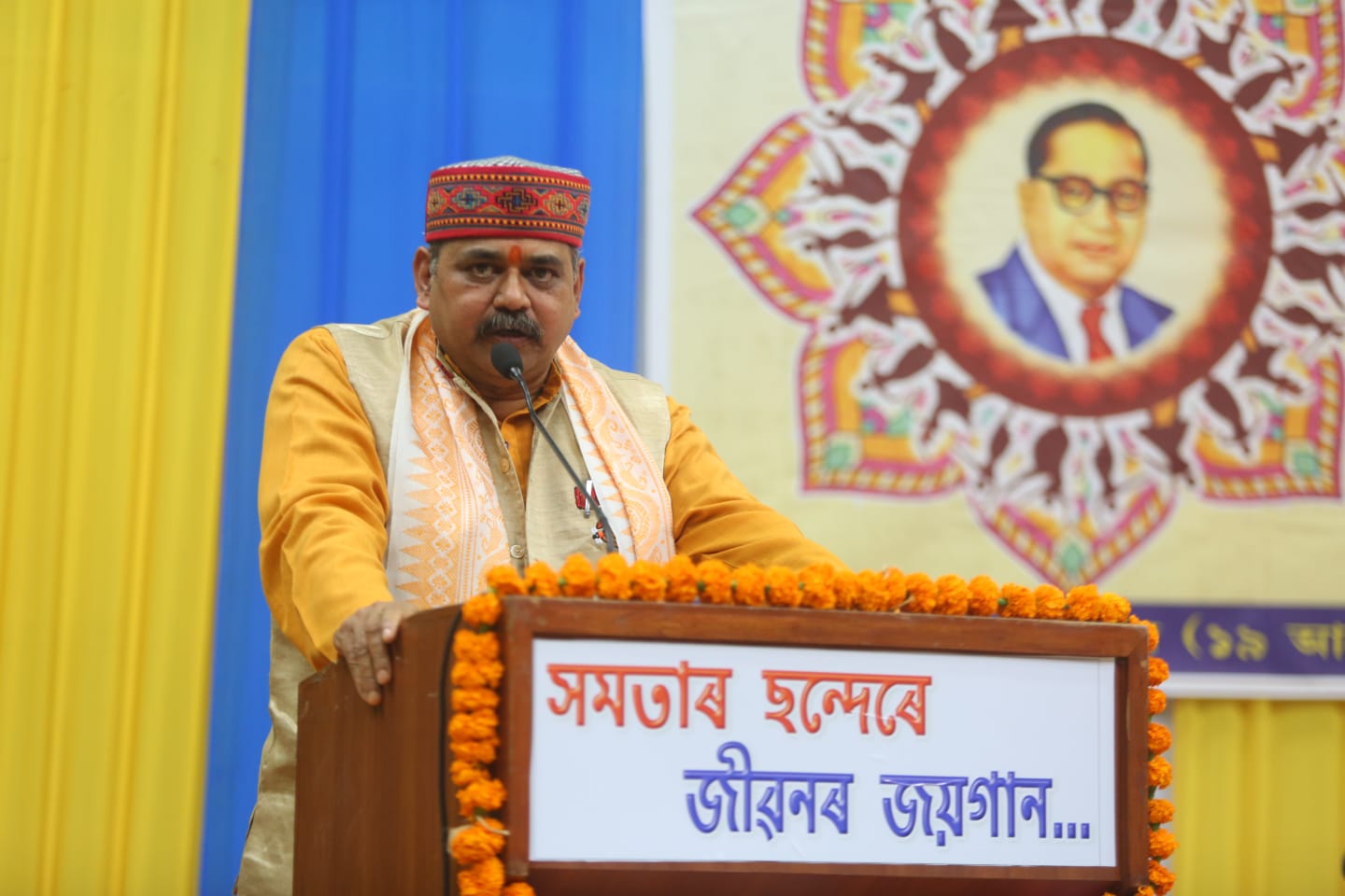 ‘समता के सुर में जीवन का जयगान’ सांस्कृतिक कार्यक्रम को संबोधित करते हुए आरएसएस नेता वशिष्ठ बुजरबरुवा की तस्वीर।