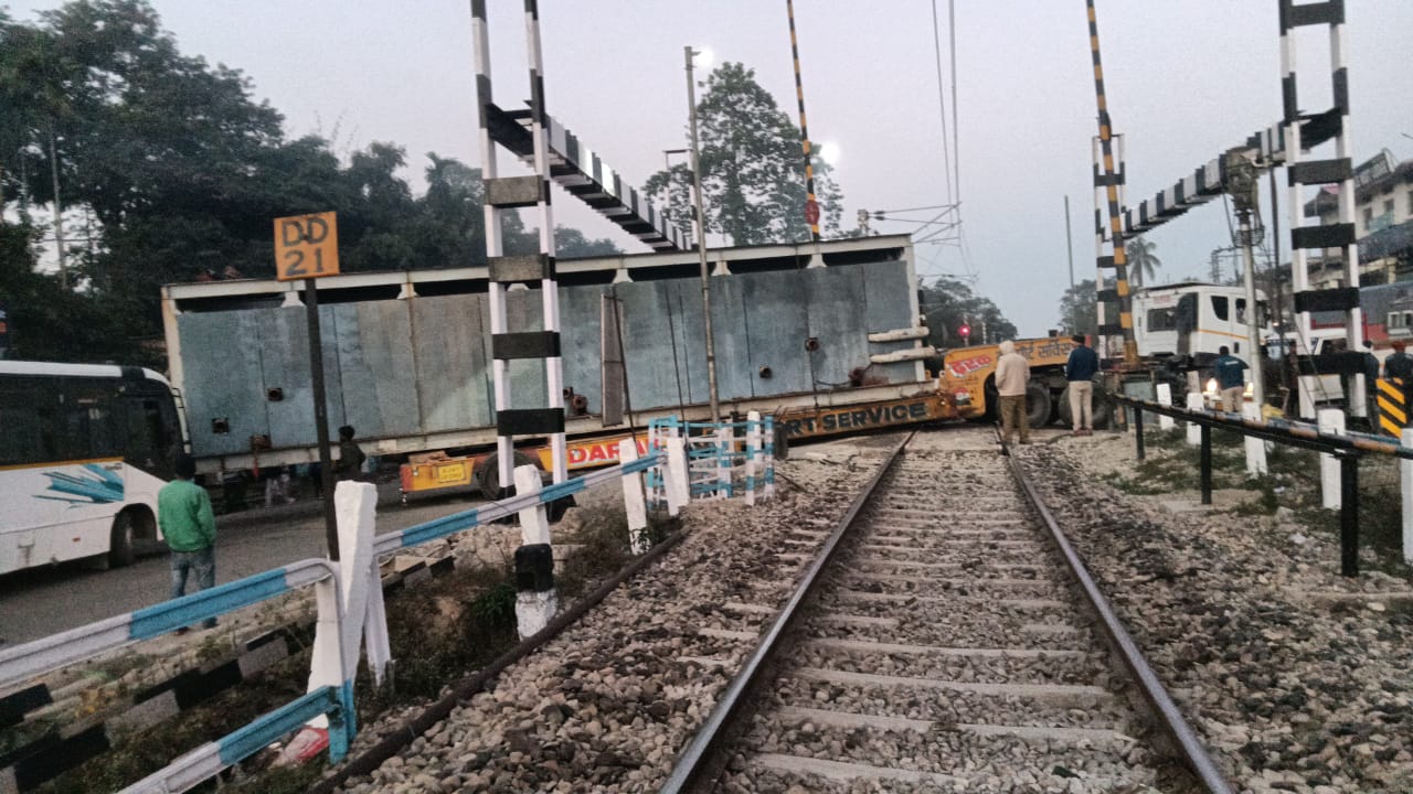 रेलवे फाटक पर फंसे ओवरसाइज ट्रक की तस्वीर।