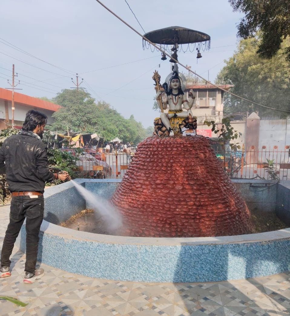 फूलबाग चौराहे पर स्थित प्रतिमा की साफ सफाई करता नगर निगम कर्मी