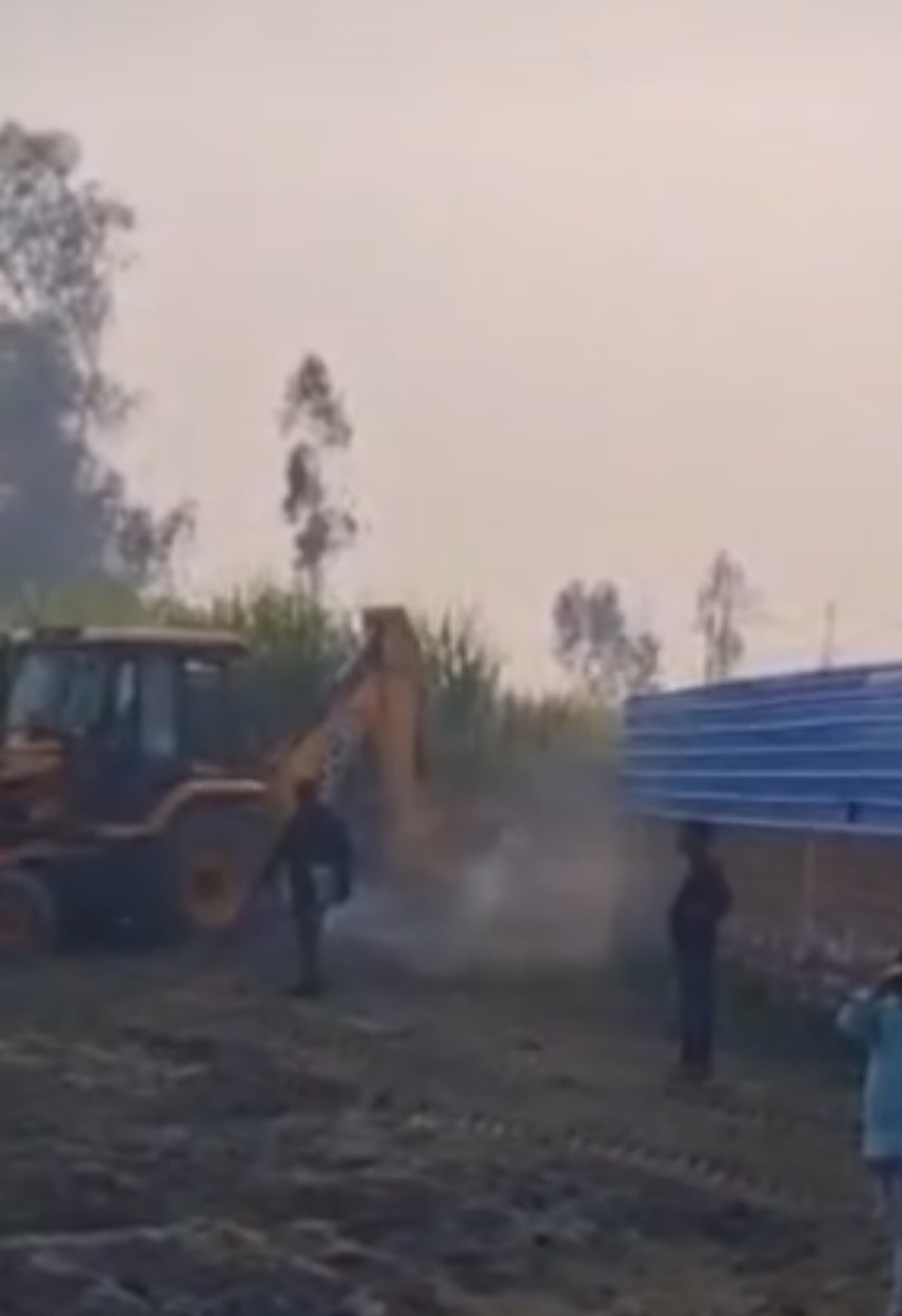 तालाब पर हुए अतिक्रमण को हटाता बुलडोजर