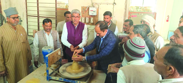 चाक पर माटी का बर्तन बनाने का प्रयास करते अतिथि