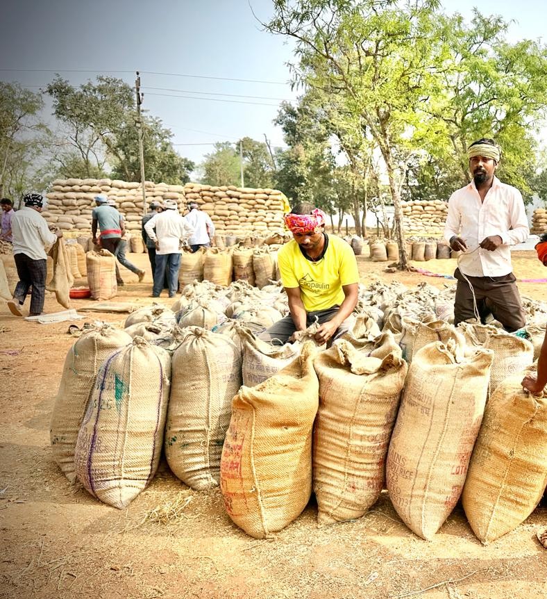 धान उपार्जन केंद्र में धान की तौलाई करते हुए किसान।