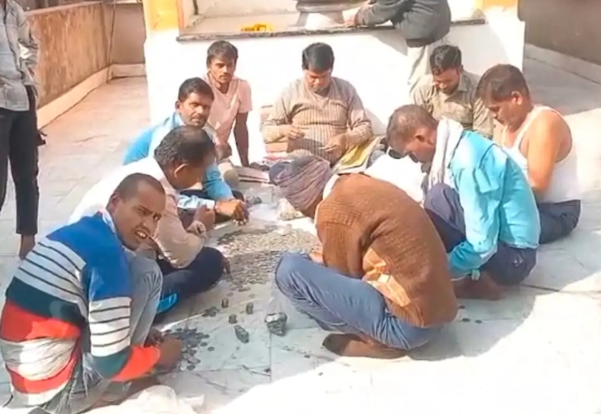 मौके पर सिक्के गिनते श्रद्धालु