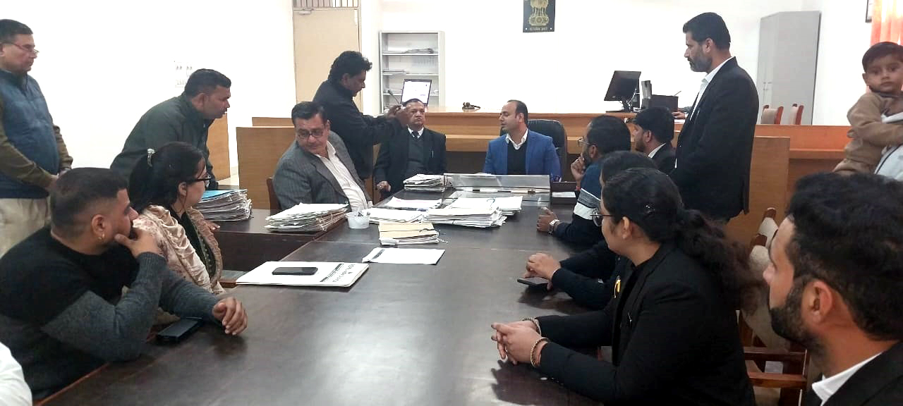 राष्ट्रीय लोक अदालत में केसों का निपटारा करते न्यायाधीश।