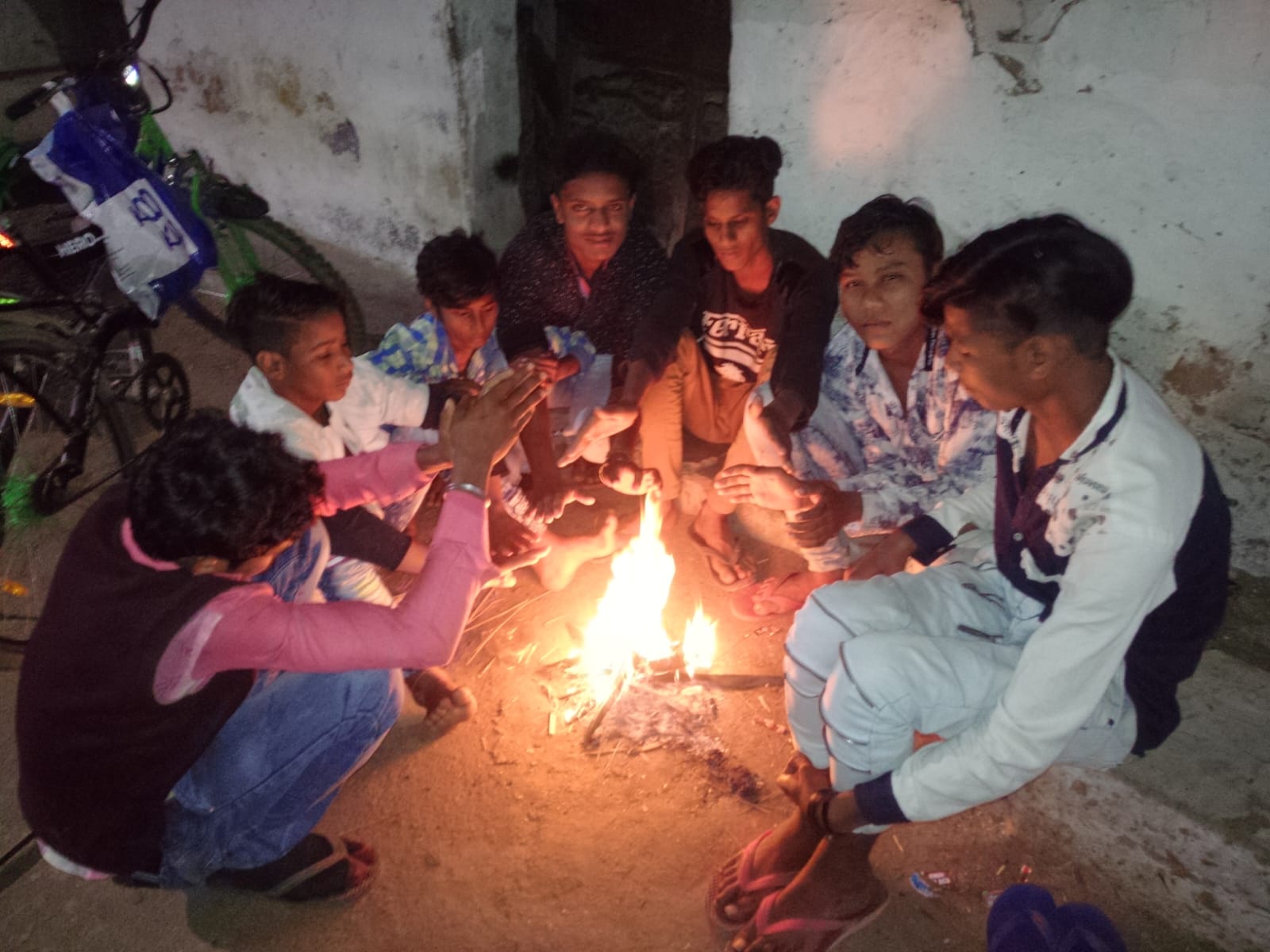 अलाव ताप रहे स्कूली छात्र।