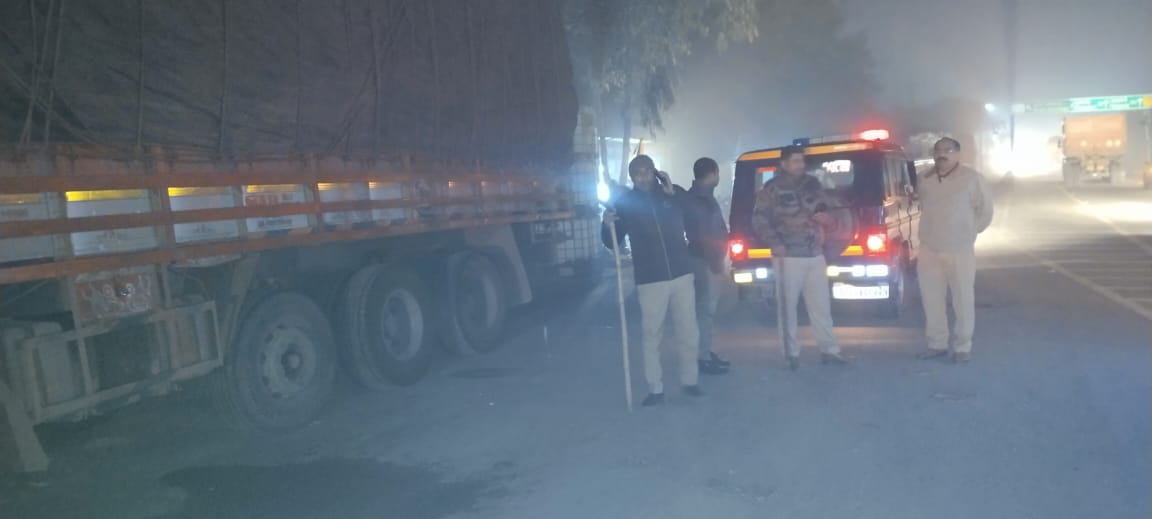 हाईवे किनारे खड़ी गाड़ी को हटवाते हुए पुलिस कर्मी