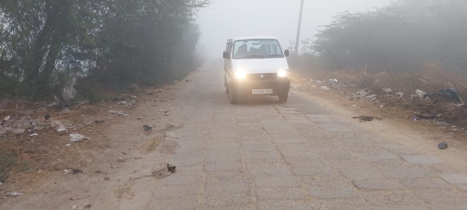 कोहरे में लाइट जला कर गुजरते हुए वाहन।