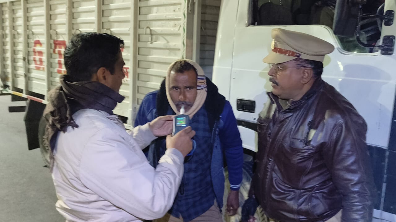 ब्रीथ एनालाइजर से शराब के नशे की जंच करते अधिकारी